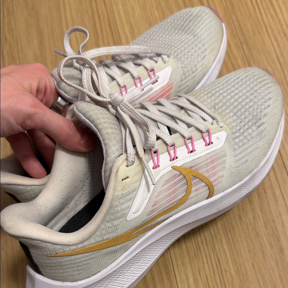 Nike Women's Light Beige Running Shoes with Gold Swoosh and Pink Accents